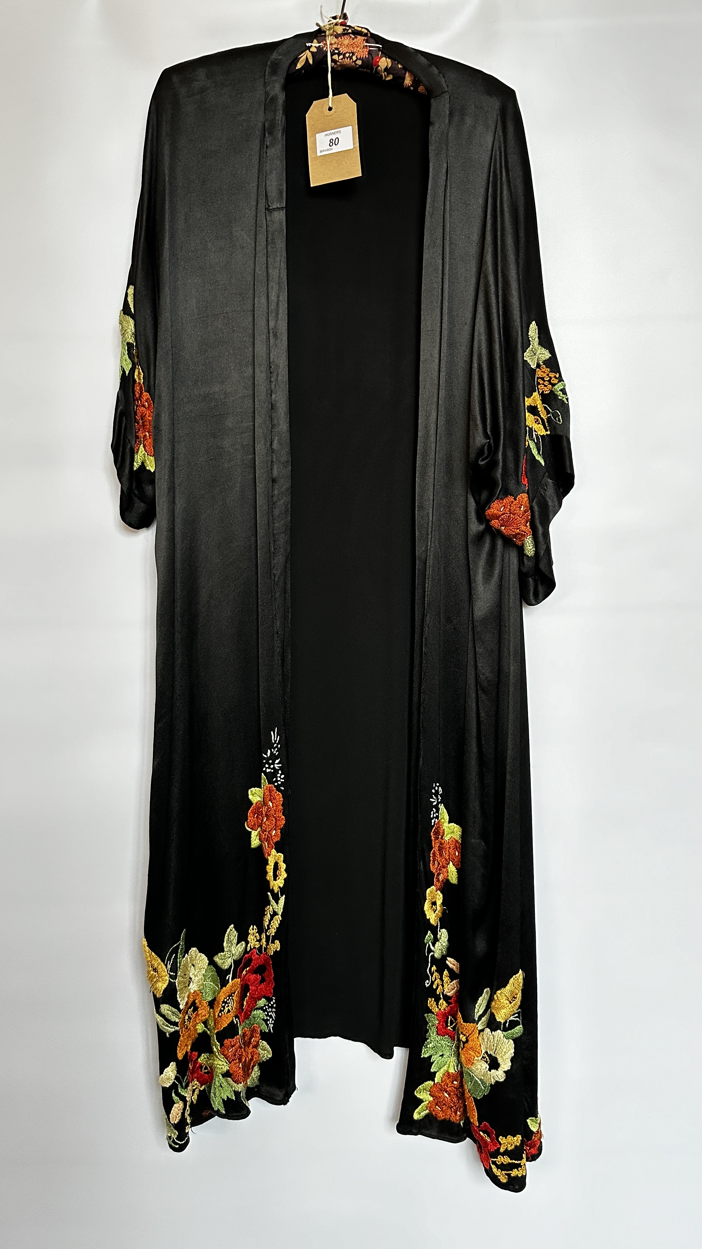 1920S BLACK SATIN ¾ LENGTH COAT WITH NASTURTIUM EMBROIDERY TO SLEEVES AND HEMLINE - A/F CONDITION,