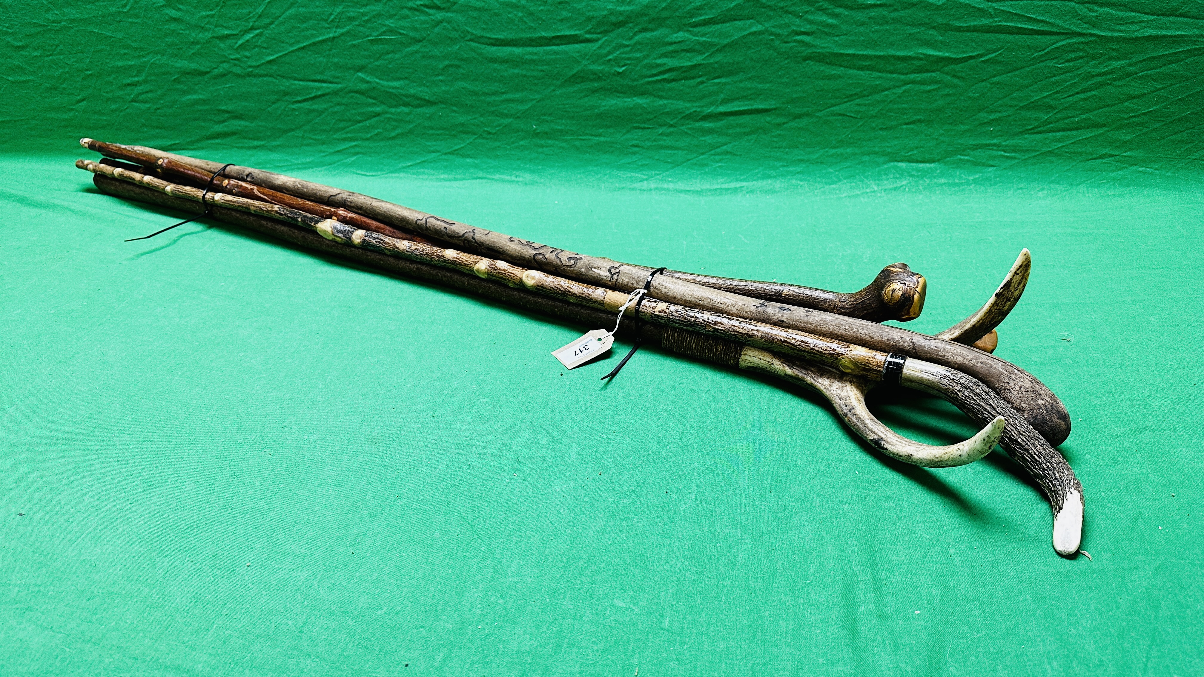 A GROUP OF FIVE VARIOUS WALKING AND SHOOTING STICKS INCLUDING HORN HANDLED CARVED, ETC.