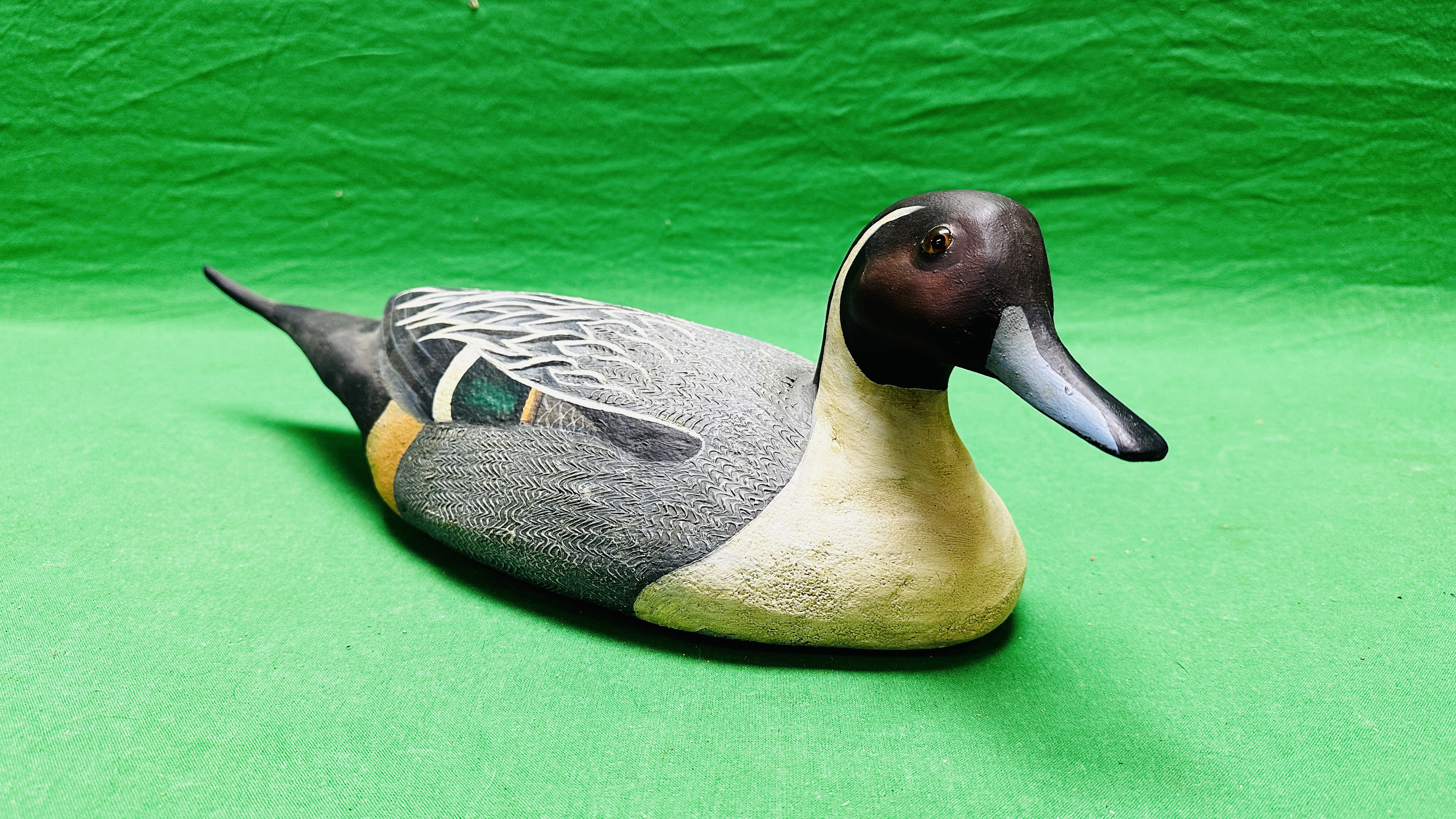 A HANDCRAFTED DUCK DECOY HAVING HANDPAINTED DETAIL AND GLASS EYES.