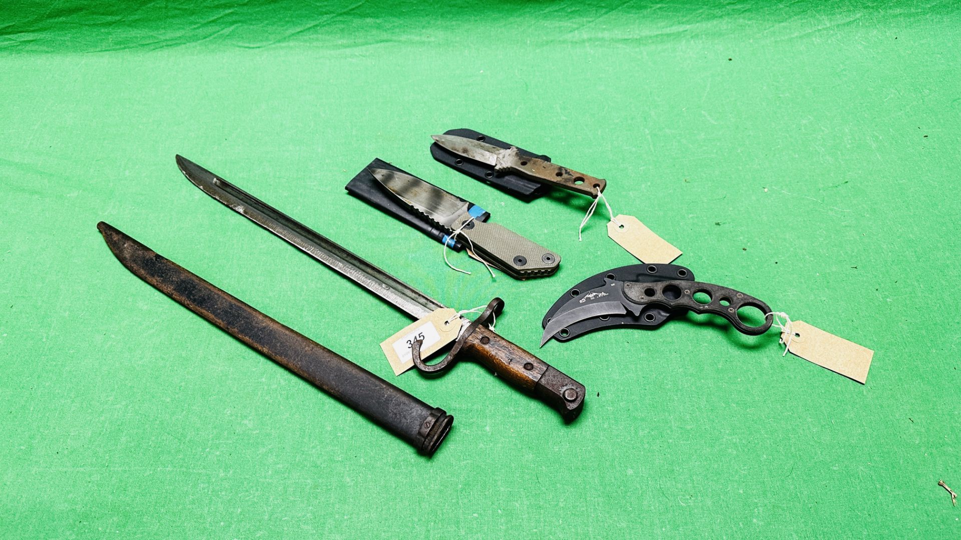 AN ANTIQUE FRENCH BAYONET WITH SCABBARD ALONG WITH THREE VARIOUS KNIVES INCLUDING EMERSON, STRIDER,
