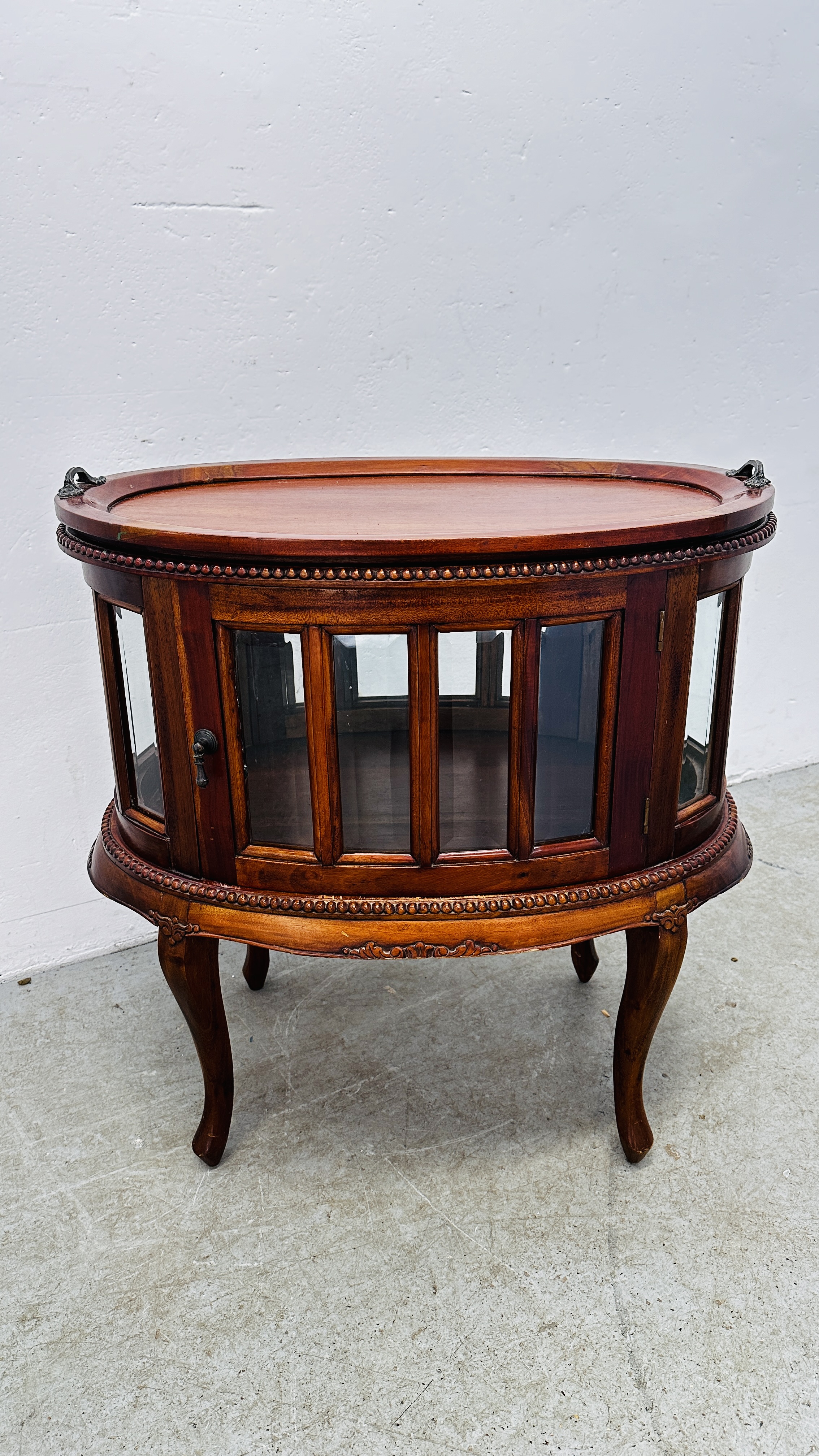 A REPRODUCTION MAHOGANY OVAL DRINKS CABINET WITH TRAY TO TOP,