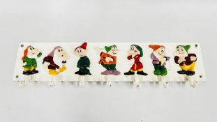 A REPRODUCTION CAST COAT HOOK DEPICTING THE 7 DWARFS. W 58 X H 12.5CM.