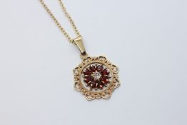 AN ELABORATE YELLOW METAL STONE SET FLOWER HEAD PENDANT (RUBBED MARKS) ON A 9CT GOLD CHAIN, L 54CM.