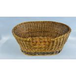 A TRADITIONAL WICKER PET BASKET.