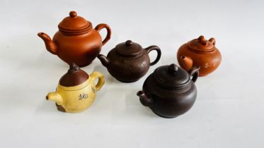 A GROUP OF FIVE VARIOUS ORIENTAL POTTERY TEAPOTS.