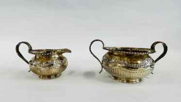 AN ELABORATE SILVER TWO HANDLED SUGAR BASIN AND MATCHING CREAM JUG DECORATED WITH EMBOSSED FLOWER