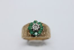 A VINTAGE 9CT GOLD DIAMOND AND EMERALD CLUSTER RING.