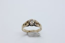 A 9CT GOLD DIAMOND SOLITAIRE RING IN A RAISED SETTING.