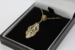 A 9CT GOLD OPEN WORK PENDANT IN THE FORM OF A LEAF ON A WOVEN 9CT GOLD CHAIN, L 44CM.