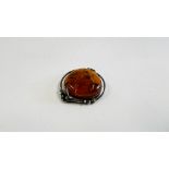 A VINTAGE SILVER BROOCH INSET WITH AN AMBER TYPE STONE.