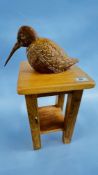 A SMALL PINE OCCASIONAL TABLE AND A CARVED BIRD STUDY.