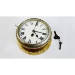 A VINTAGE BRASS CASED SHIPS CLOCK WITH ENAMELLED DIAL.
