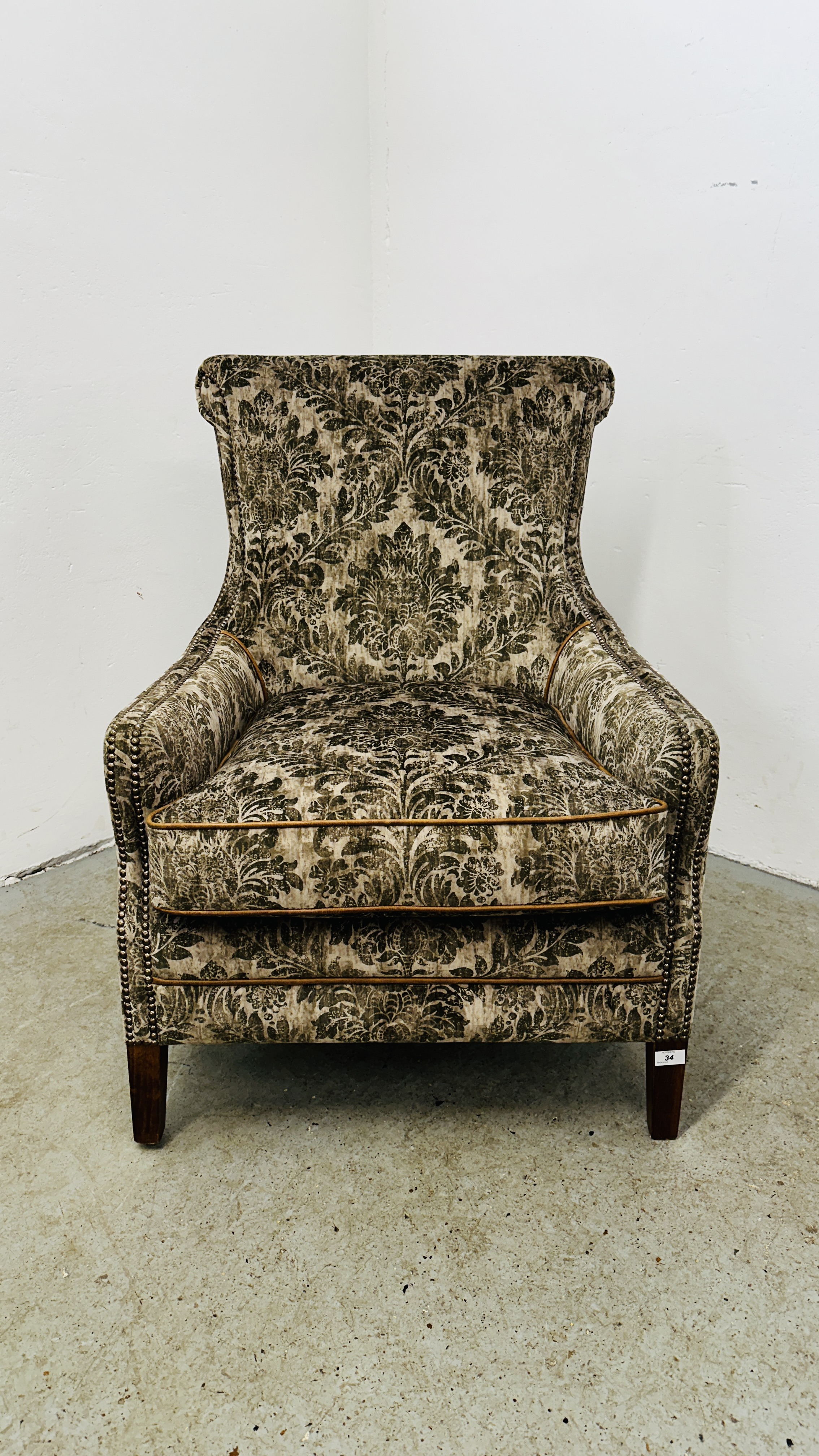 A GOOD QUALITY MODERN ARM CHAIR UPHOLSTERED IN GREEN JUNGLE PATTERNED FABRIC.