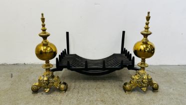 AN IMPRESSIVE PAIR OF BRASS FIRE DOGS WITH HEAVY CAST IRON LOG BASKET, HEIGHT 58CM, WIDTH 100CM.