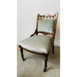 A VICTORIAN MAHOGANY AND INLAID NURSING CHAIR WITH BLUE UPHOLSTERY ON CASTORS.