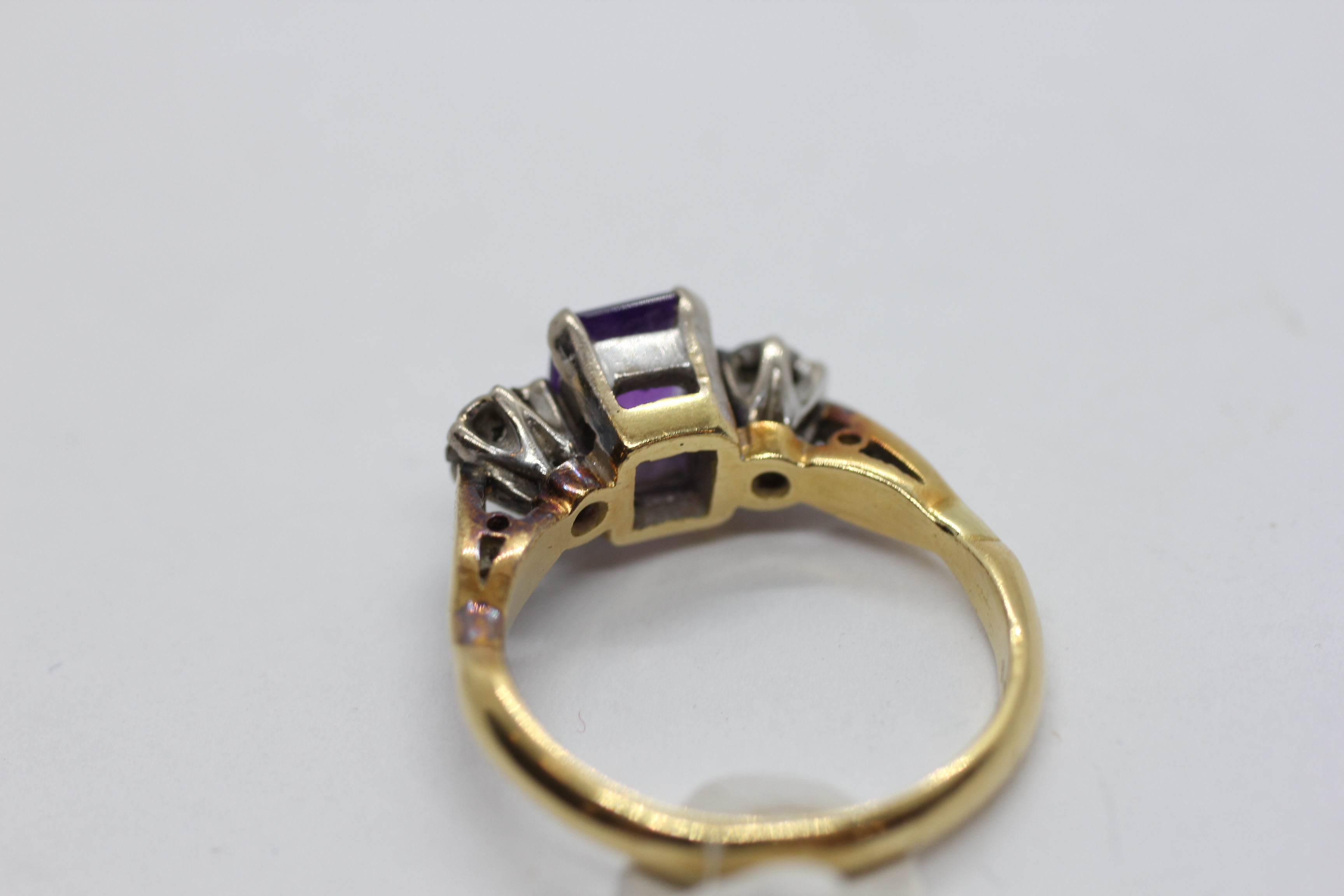 AN 18CT GOLD RING SET WITH A CENTRAL EMERALD CUT AMETHYST AND A DIAMOND EITHER SIDE. - Image 7 of 7