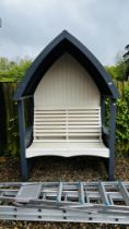 AN ARCHED WOODEN GARDEN ARBOUR SEAT W 140CM.