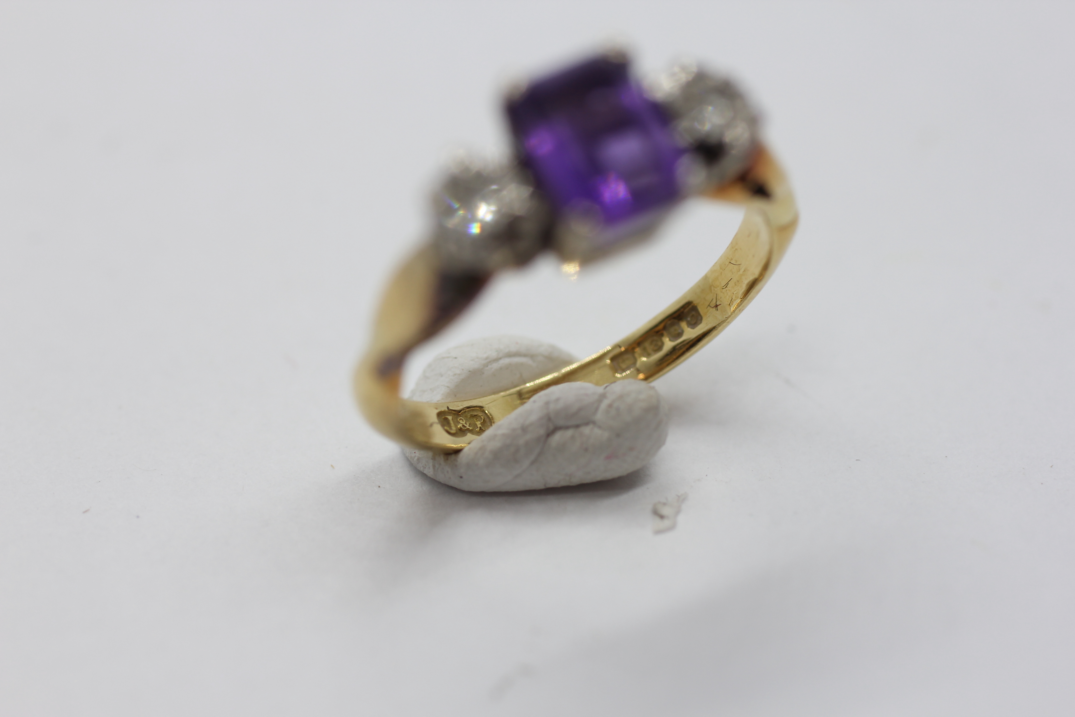 AN 18CT GOLD RING SET WITH A CENTRAL EMERALD CUT AMETHYST AND A DIAMOND EITHER SIDE. - Image 4 of 7