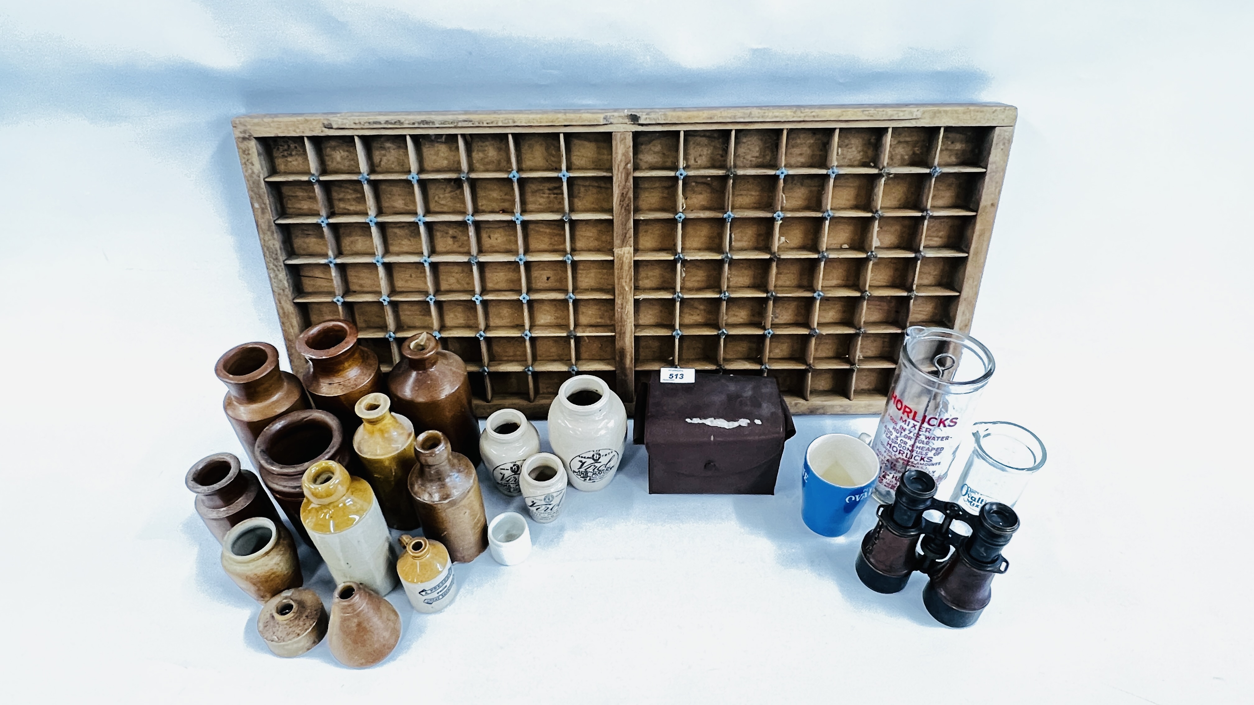 A PRINTERS TRAY ALONG WITH A COLLECTION OF SIXTEEN OLD STONEWARE BOTTLES AND JARS TO INCLUDE VIROL