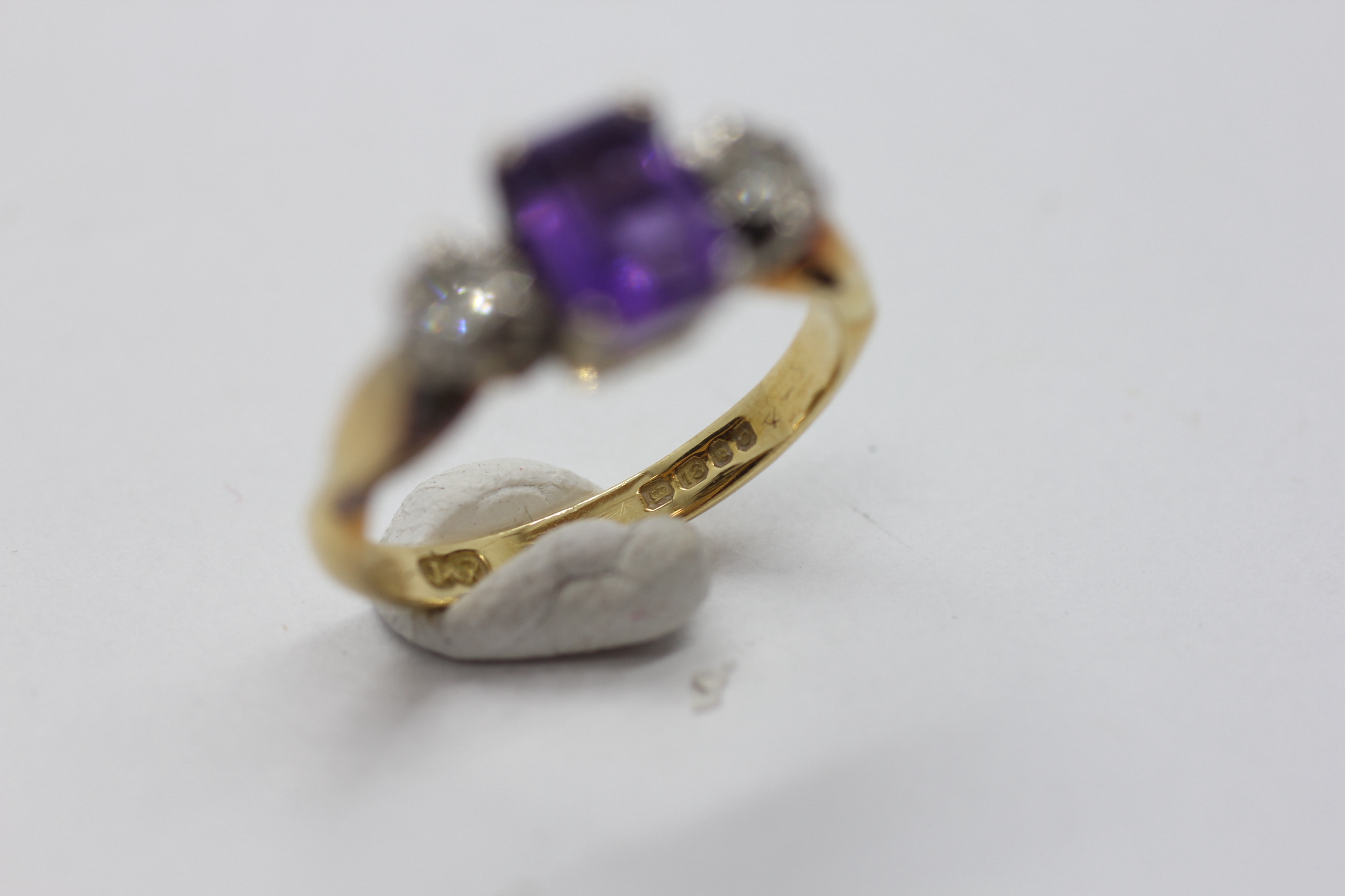 AN 18CT GOLD RING SET WITH A CENTRAL EMERALD CUT AMETHYST AND A DIAMOND EITHER SIDE. - Image 5 of 7