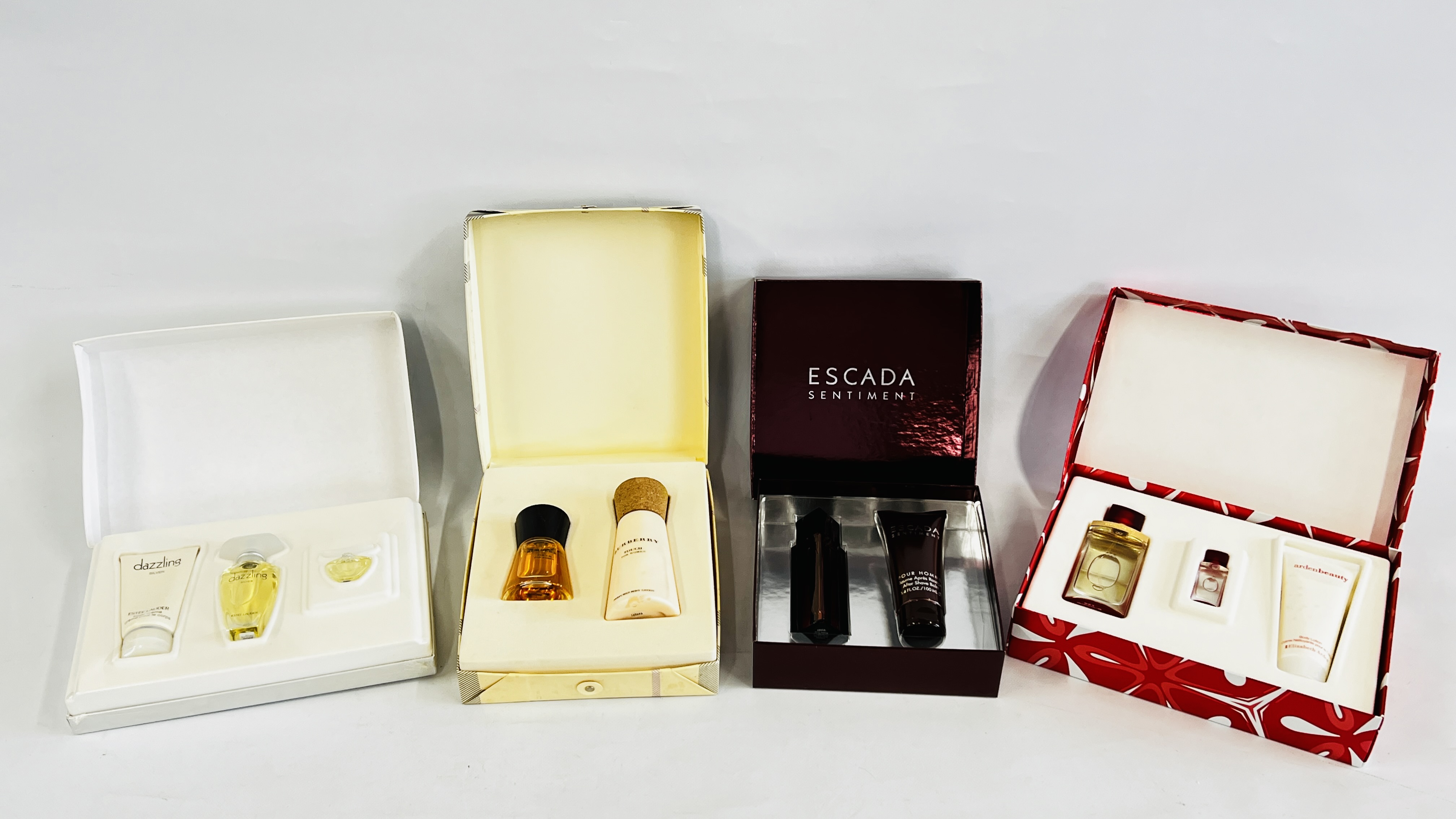A GROUP OF 4 BOXED PERFUME GIFT SETS TO INCLUDE EXAMPLES MARKED "ESTEE LAUDER" DAZZLING SILVER,