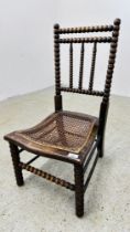 A VINTAGE BOBBIN TURNED LOW CHAIR WITH BERGERE WORK SEAT BEARING ORIGINAL MAKERS LABEL J.