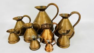 A SET OF 9 GRADUATED VINTAGE COPPER MEASURING JUGS.