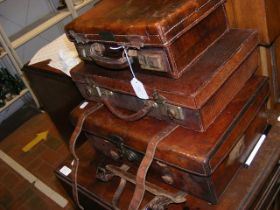 Three vintage leather suitcases of varying size