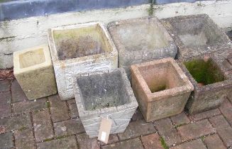 Seven concrete garden planters of varying size