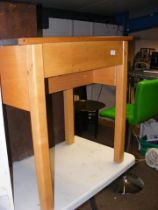 A light wood school desk with lift-up top