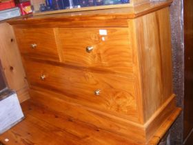 A light wood low lying chest of two short and one