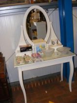 A contemporary dressing table with oval swing mirr