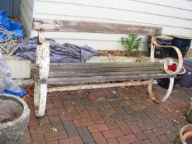 A large garden bench with wrought metal ends - len