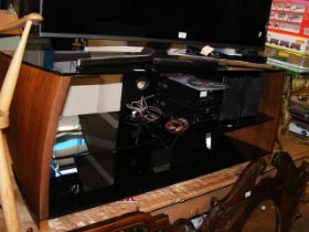 A three tier smoke glass TV and sound system stand