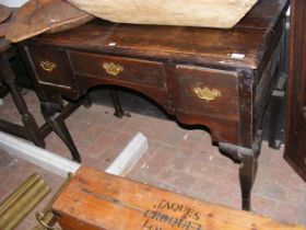 An oak lowboy with three drawers to the front on c