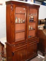 A Victorian glazed bookcase with drawers and cupbo