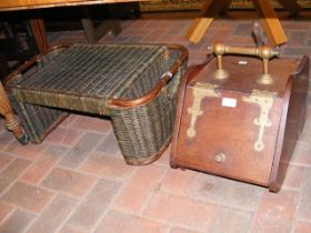 An antique coal scuttle with decorative brass hing