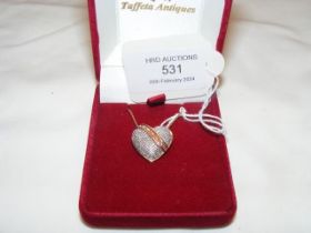 A heart shaped diamond mounted pendant on gold cha