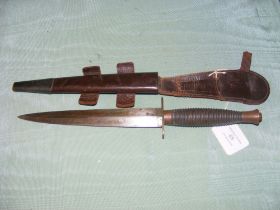 A fighting knife with ribbed grip, in leather sc
