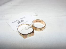 A gold wedding band together with gents ring