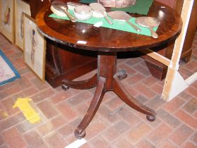 An antique circular tilt top table with cross band