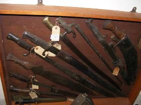 A display cabinet containing eight antique bayonet