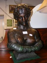 A bronzed bust of partially robed woman