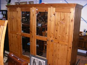 A pine four door wardrobe with acorn carved motif