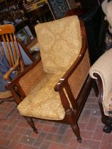 An old Bergere armchair with reeded front support