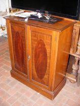 An antique mahogany two door cupboard with decorat