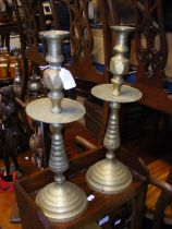 A pair of brass Egyptian style candlesticks