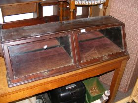 A tabletop sloped front display cabinet