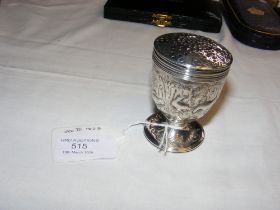 A George III silver pepperette with repousse decor