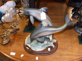 A sculpted dolphin ornament, signed to the base